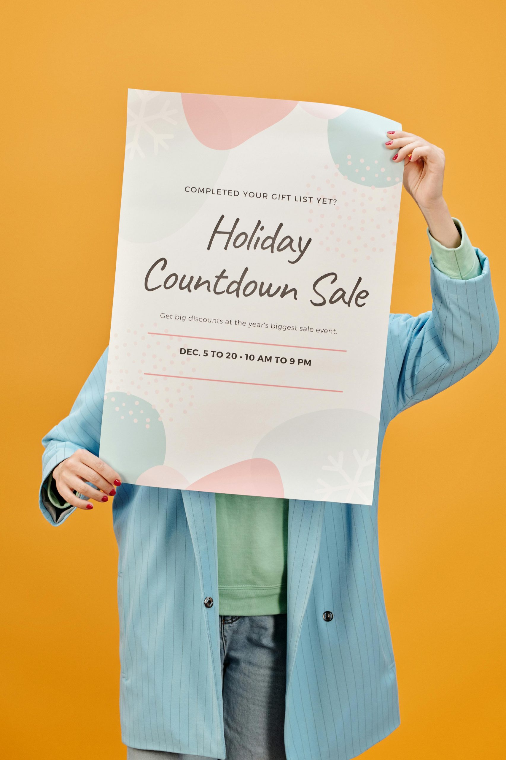 Person holding a holiday sale poster against a vibrant yellow backdrop.